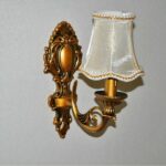 Candle-shaped fabric wall sconce, gold-colored base and white fabric