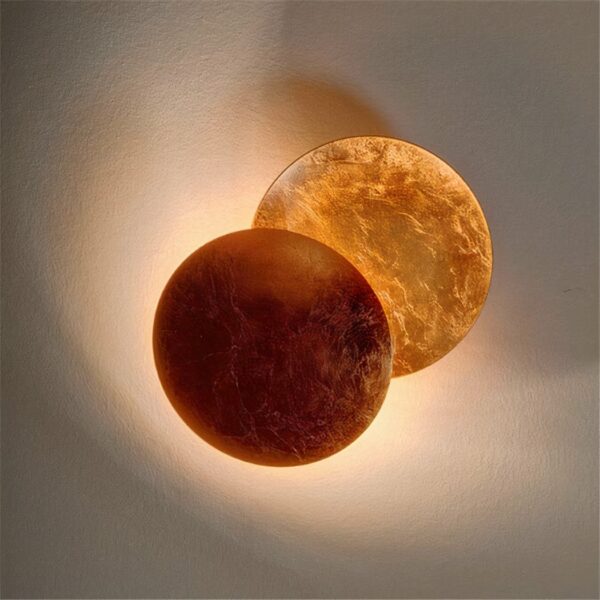 On a white background, a brown moon eclipse wall light is lit.