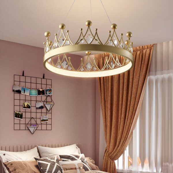 Gold crown chandelier for baby's room, with crystal stones on top, in a room with pink walls