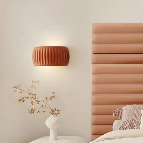 Orange resin wall lamp, next to a bed