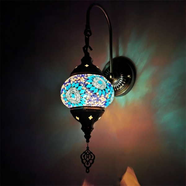 Oriental wall light in blue glass mosaic presented lit in the dark