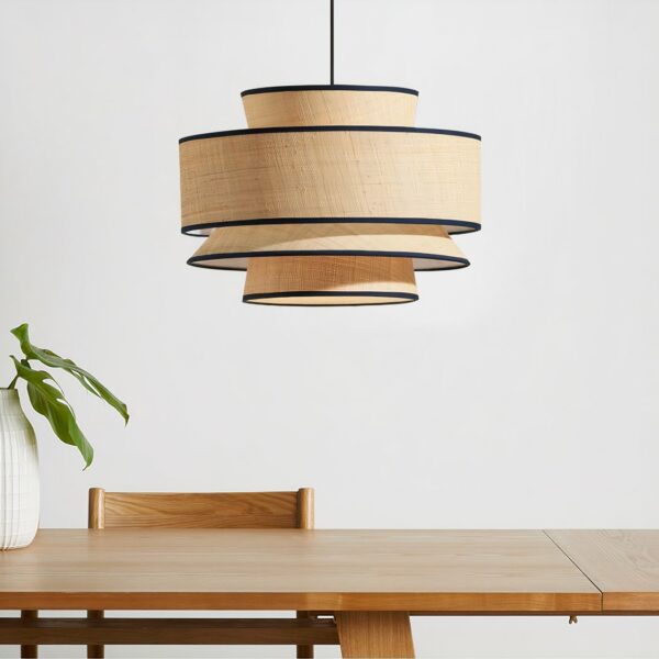 Round Japanese suspension lamp with fabric tiers above a dining table with wooden chair