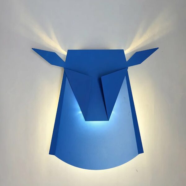 Blue LED metal deer wall light. Minimalist design. The light diffuses the stag's horns on a white wall.
