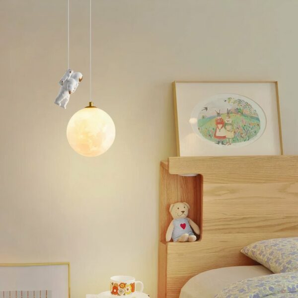 Nordic-style resin chandelier with astronaut on beige background with bed on right