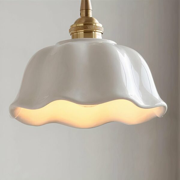 White wavy ceramic hanging lamp in the vintage style of an old farmhouse, lit on a white background.