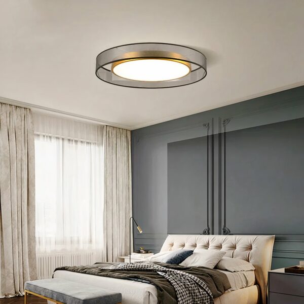 70s-style adult bedroom chandelier in fabric and gilded metal hanging from the ceiling of a bedroom and lit.