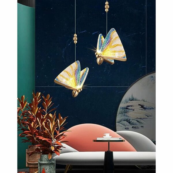 in a living room with a dark green wall, two multicolored butterfly-shaped pendant lights are shown