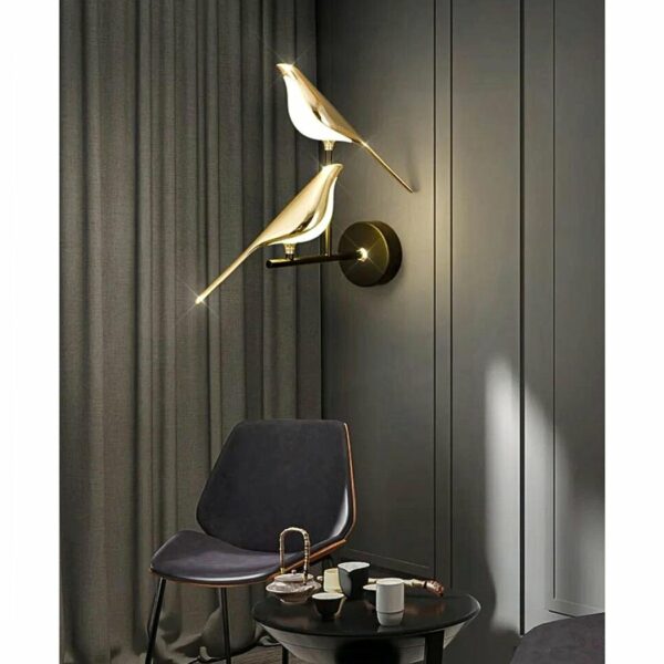 in a dark-gray living room, a wall sconce featuring a pair of birds on a golden branch