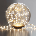 Close-up of the glass sphere with warm fairy lights inside