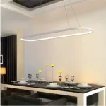 White oval LED ring pendant light hanging above a set dining table