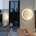 Two crescent moon wall lights glowing warm on an outdoor patio at dusk