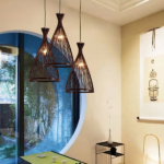 Three woven rattan cone pendant lights above a dining table by a window