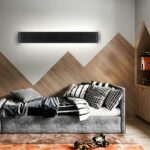 Black linear bar LED wall light above a daybed with mountain patterned wood