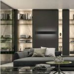 Black linear bar LED wall light glowing between backlit bookshelves