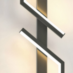 Close-up of a black zigzag linear LED wall light glowing warm