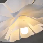 Close-up of the white wavy acrylic petals surrounding the light source of the flower ceiling lamp