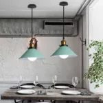 Two mint-green cone-shaped pendant lamps hanging above a set restaurant table