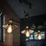 Close-up of the three cone shades and pulley wheel glowing warmly