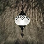 Moroccan style pendant lamp with a crackled glass globe and lace metal pattern