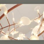 Close-up of a copper branch chandelier with glowing oval leaf lights
