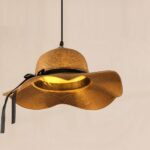 Straw hat pendant light seen from below glowing with warm light