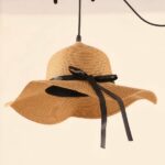 Straw hat pendant light photographed from above with the cord against a white ceiling