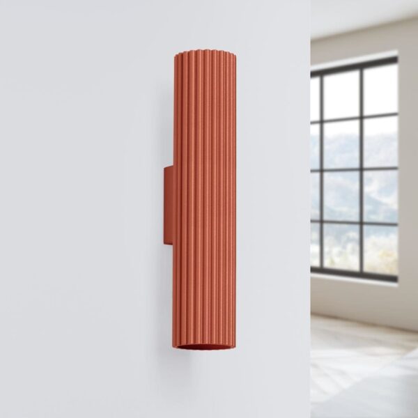 Ribbed cylindrical wall light in terracotta mounted beside a window