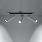 Lit white ceiling lamp with three cylinder spotlights angled downward