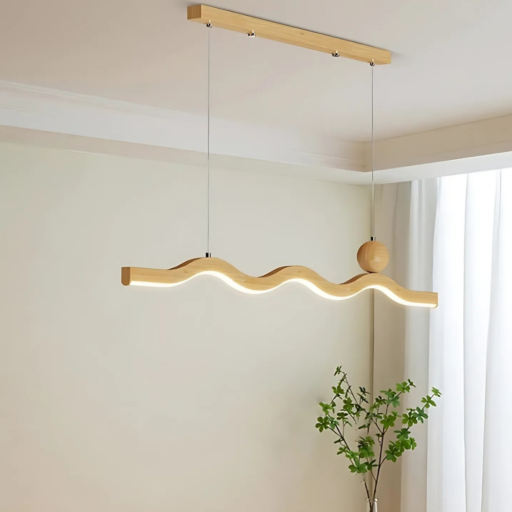 Wavy wood pendant light bar above a table beside a curtain, switched off