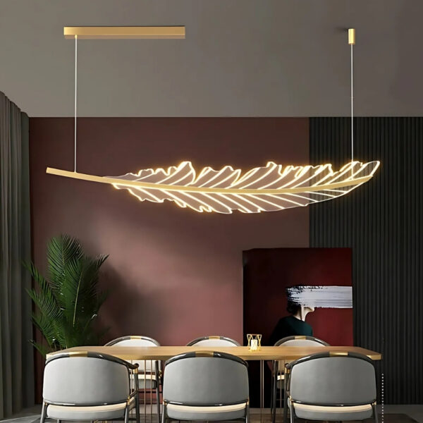 Gold leaf-shaped LED pendant light glowing above a dining table