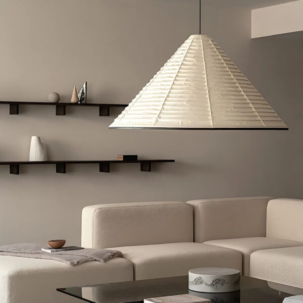 Cream pyramid-shaped pleated paper pendant light above a sofa