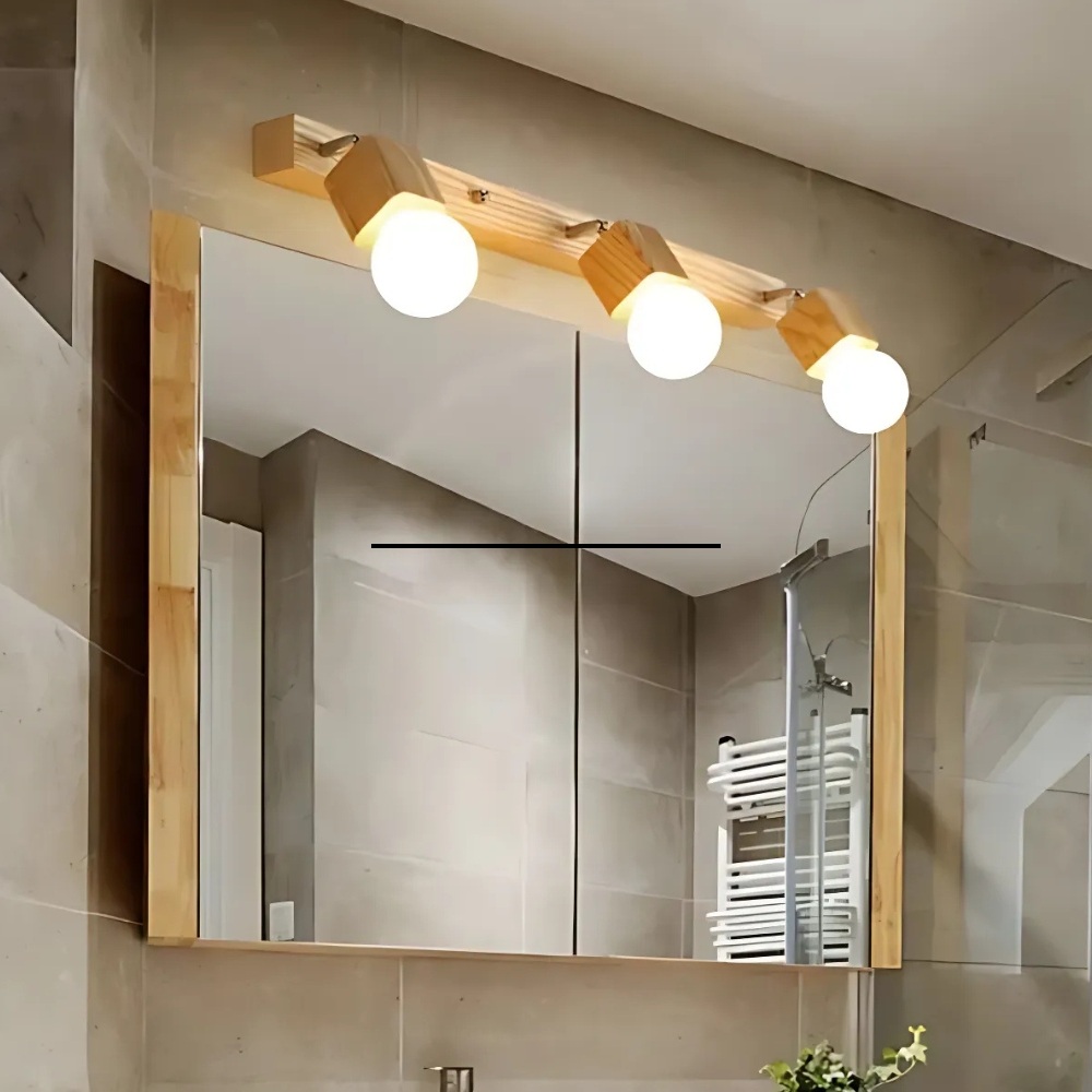 Wooden bathroom vanity light with three round bulbs above a wood-framed mirror