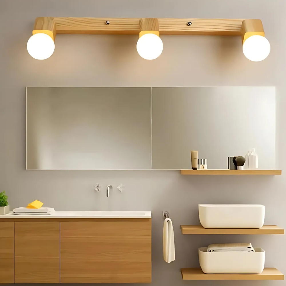 Wood bar wall light with three round bulbs above a bathroom mirror