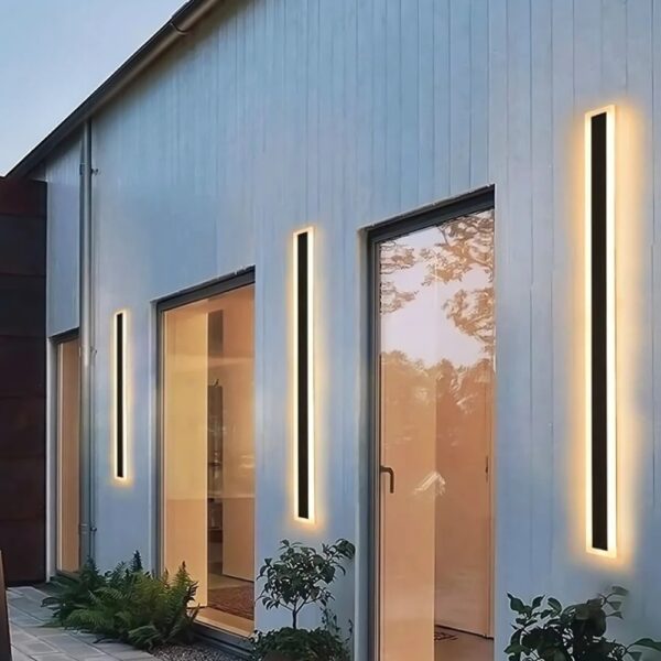 Vertical LED strip wall lights lining a house facade at dusk