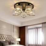 Black crystal ceiling chandelier with faceted glass prisms over a bed