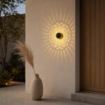 Mandala wall light casting a sunburst pattern of light beside a wooden door