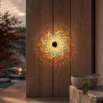 Mandala wall light casting a colourful floral pattern onto a wooden door at night