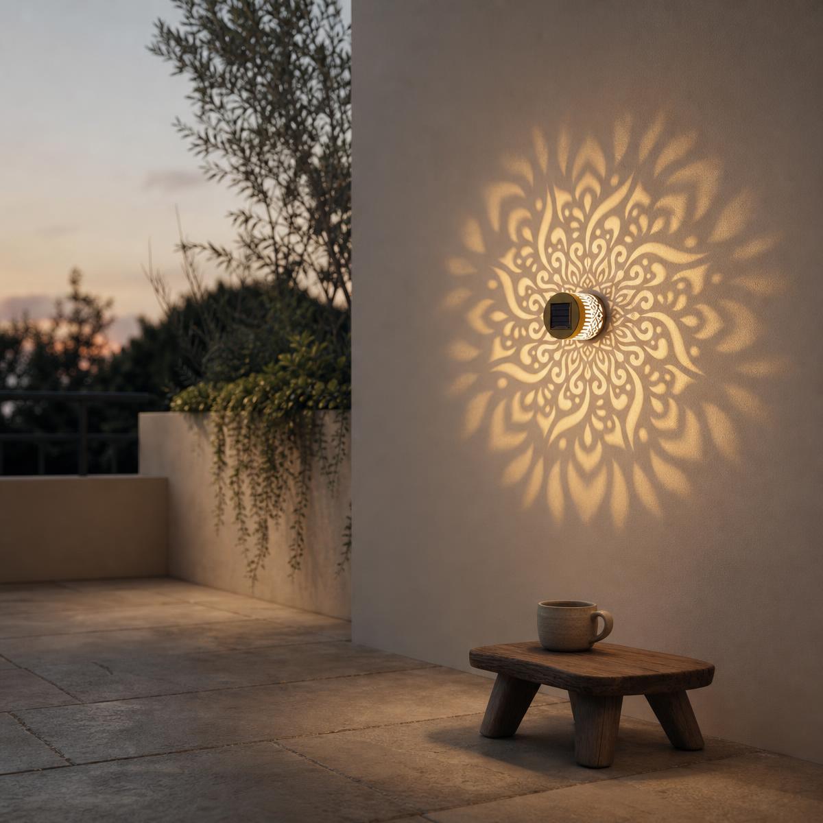 Mandala wall light casting a golden floral pattern onto a white terrace wall