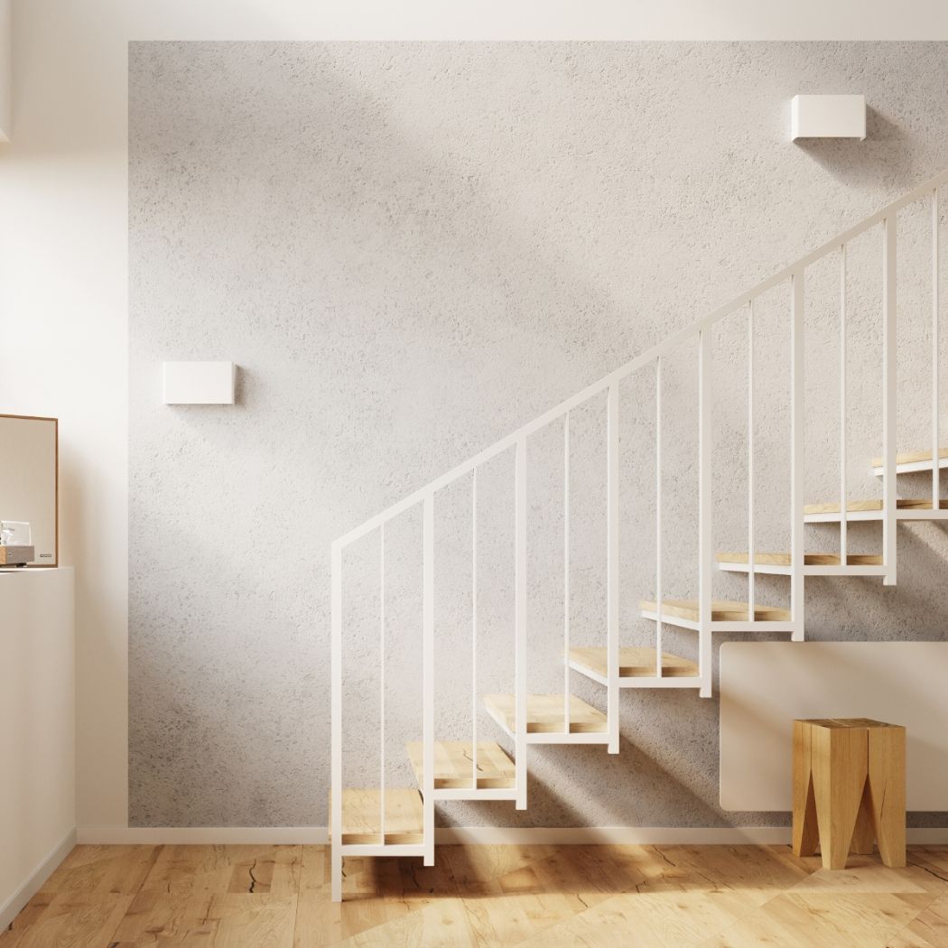 Two small square white wall lights along a staircase wall