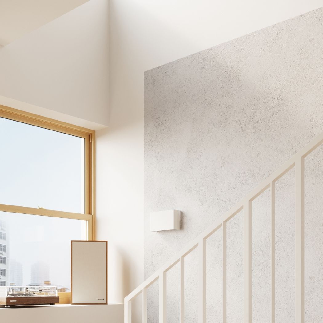 Square white wall light near a window overlooking the city beside a staircase