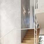 Two small white rectangular wall lights glowing on a two toned wall beside a staircase
