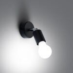 Black adjustable wall spotlight lit with a glowing bulb
