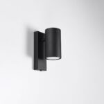 Black cylindrical wall light angled outward from a rectangular bracket