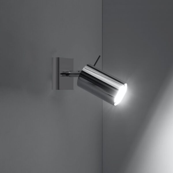 Chrome cylindrical spotlight wall light illuminating a corner