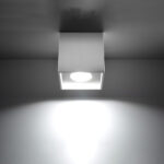 White square ceiling light glowing with a wide beam spreading downward