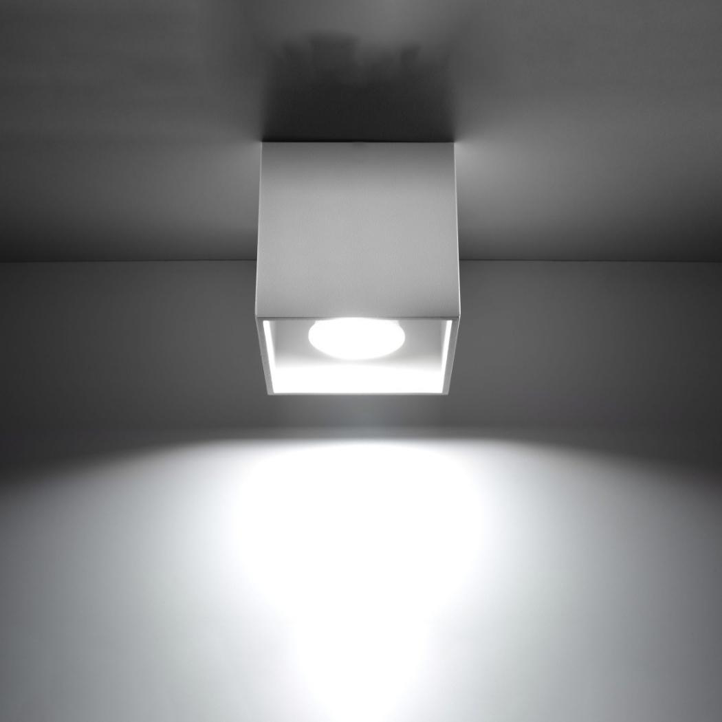 White square ceiling light glowing with a wide beam spreading downward