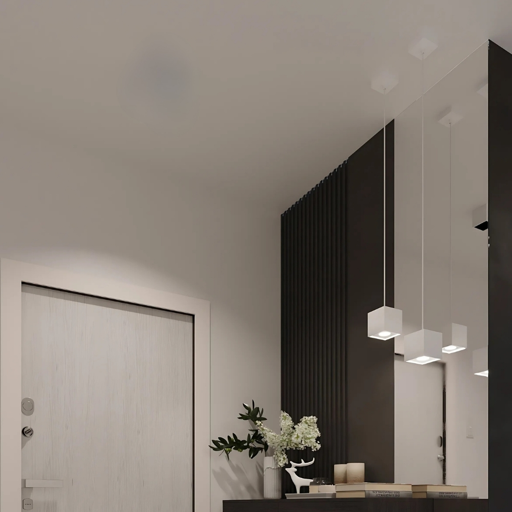 Three white cube pendants at staggered heights above an entryway console with a deer figurine