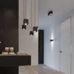 Cluster of black cube pendants beside black cube ceiling spotlights in a corridor entrance