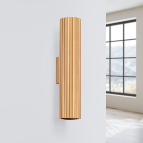 Gold ribbed elongated cylindrical wall light with light at both ends