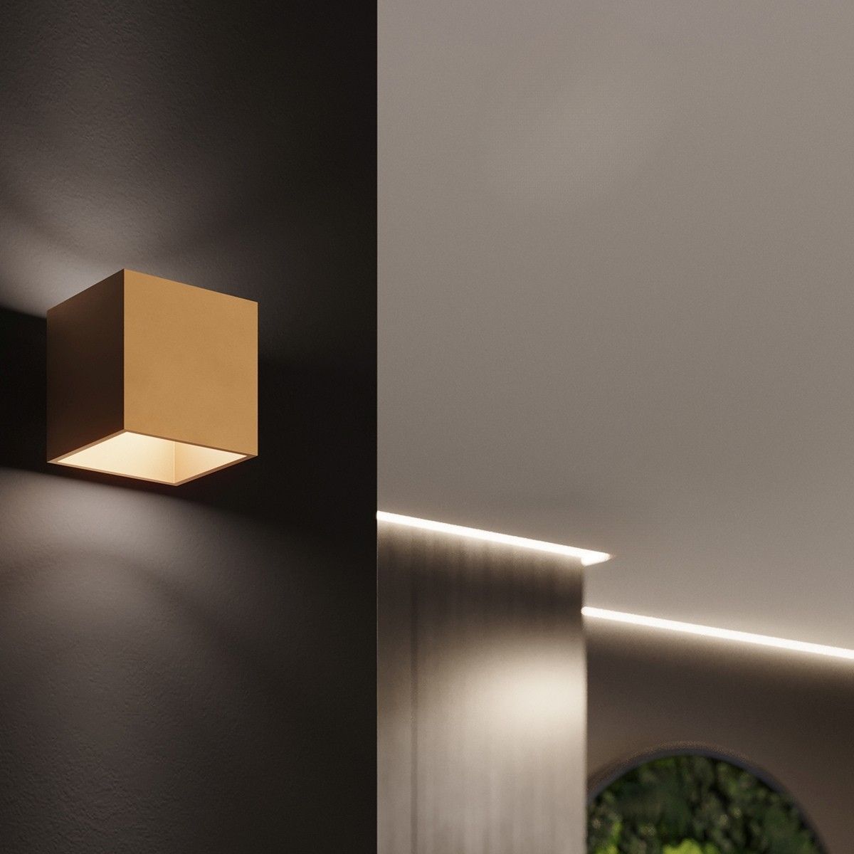 Gold cube wall light glowing on a dark wall beside an illuminated ceiling cove and staircase